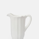 Mosser Glass moulded milk white panelled pitcher with irregular scalloped rim.